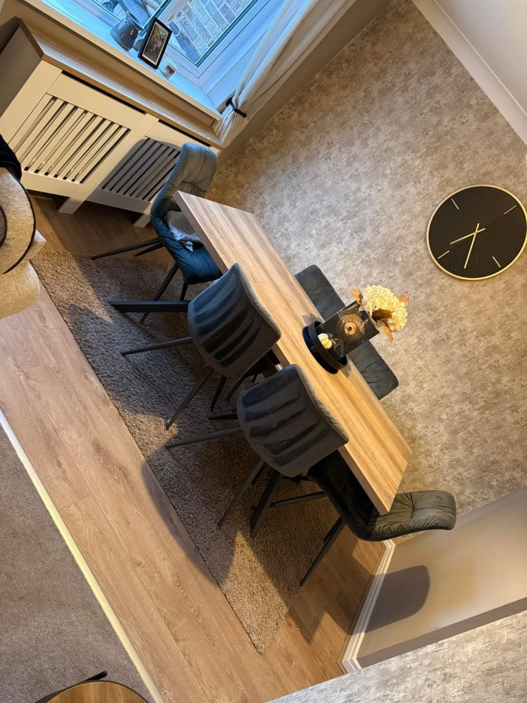 Modern office interior with wooden desk, black chairs, and gray flooring viewed from above